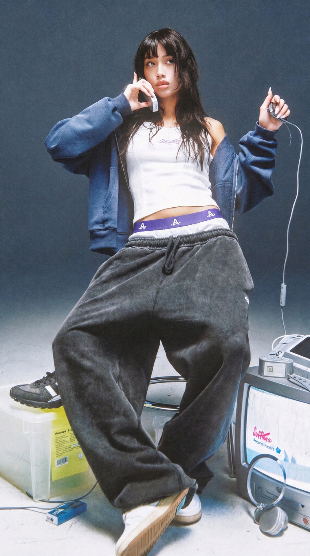 Model wearing Action Replay boxer waistband with oversized charcoal sweats and a white tank in a studio setup.